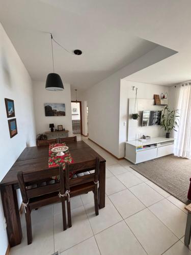 a living room with a wooden table and a kitchen at Vista inesquecível para o mar homeclub BetoCarrero in Penha