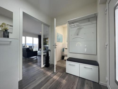 a kitchen with white cabinets and a living room at Sonnenweg 18 in Heringhausen