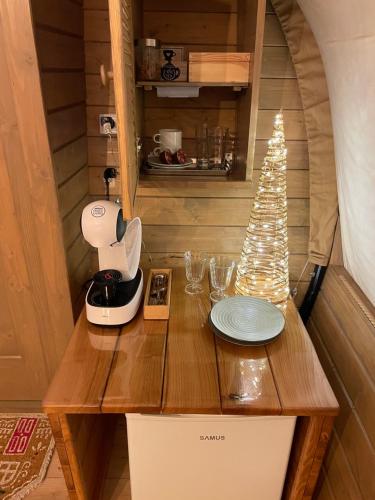 Una casita con una mesa con un árbol de Navidad. en White Spring Glamping, en Câmpulung Moldovenesc