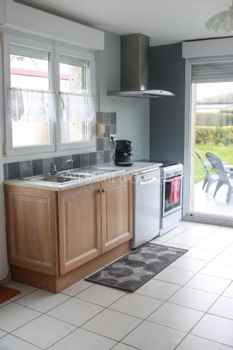 une cuisine avec un évier et une cuisinière four supérieur dans l'établissement Gîte Au Mont d'Opale, à Saint-Martin-Boulogne