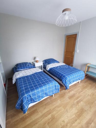- 2 lits dans une chambre avec des draps bleus dans l'établissement Gîte Au Mont d'Opale, à Saint-Martin-Boulogne