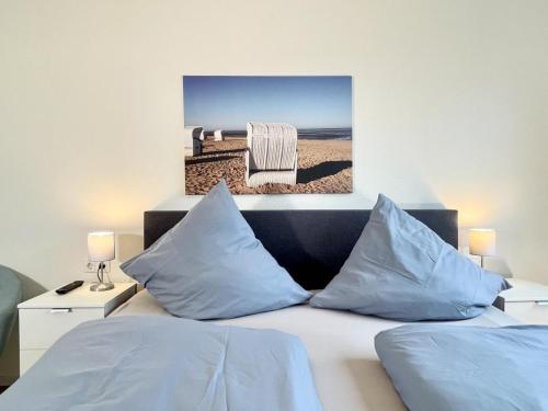 a bed with two pillows and a chair in a bedroom at Quartier Hohe Geest 22 in Cuxhaven