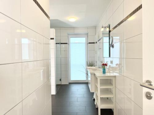 a white bathroom with a sink and a mirror at Quartier Hohe Geest 22 in Cuxhaven