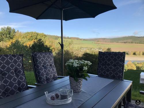 a table and chairs with an umbrella on a patio at Haus Paula - Sonnenweg 22 in Heringhausen