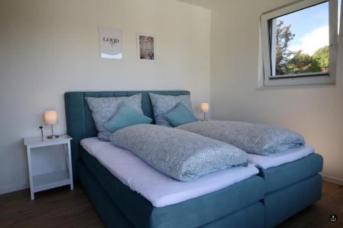 a blue couch with pillows on it in a room at Haus Paula - Sonnenweg 22 in Heringhausen
