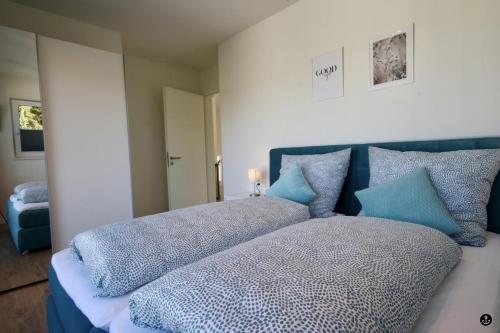 a bed with blue pillows on it in a room at Haus Paula - Sonnenweg 22 in Heringhausen