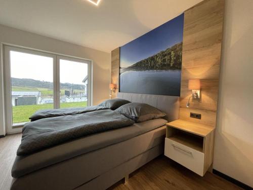 a bedroom with a large bed and a large window at Sonnenweg 31 - HAUS DIEMELSEE in Heringhausen