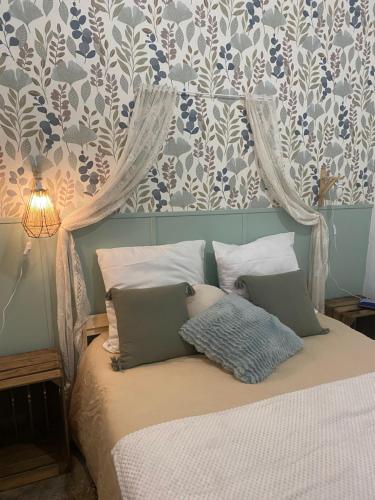 un lit avec deux oreillers dessus dans une chambre dans l'établissement Appartement cosy avec oasis privée, salle de jeux, vélos bienvenus, à Carcassonne