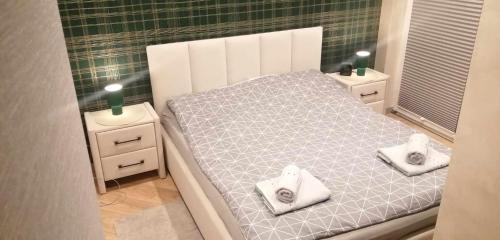 a small bedroom with a bed with towels on it at Centro Residence in Kluczbork