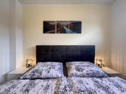 a bedroom with a bed and two pictures on the wall at Diemelblick 23 - DIEMELTJE in Heringhausen