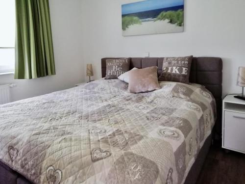una camera da letto con un grande letto con una coperta di Meeresrauschen 1 a Grossenbrode