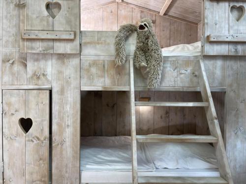 - un lit superposé avec un hibou sur une échelle dans l'établissement Lönnegarden - Backhus, à Kellenhusen