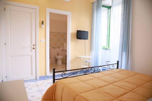 a bedroom with a bed and a bathroom with a toilet at Villa Lery - Azzurra Home in Agropoli