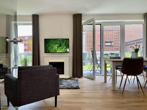 a living room with a fireplace and a table and chairs at Kellenhusen Tor 17 in Kellenhusen