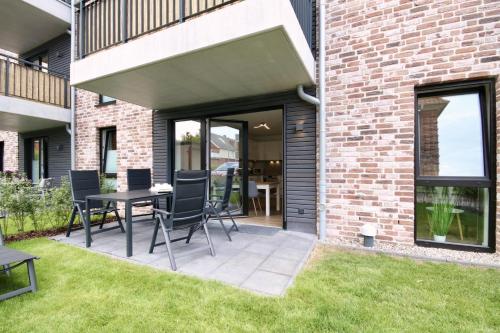 a patio with chairs and a table next to a brick building at Kellenhusen Tor 17 in Kellenhusen