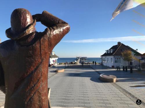 a statue of a person looking out at the ocean at Kellenhusen Tor 11 in Kellenhusen