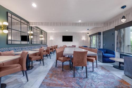 a dining room with tables and chairs and a flat screen tv at The Newberry Hotel Bend, Tapestry Collection by Hilton in Bend