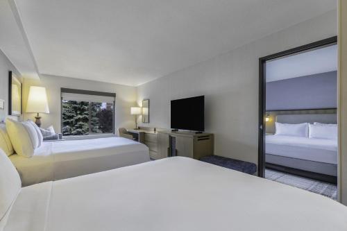 a hotel room with two beds and a television at The Newberry Hotel Bend, Tapestry Collection by Hilton in Bend