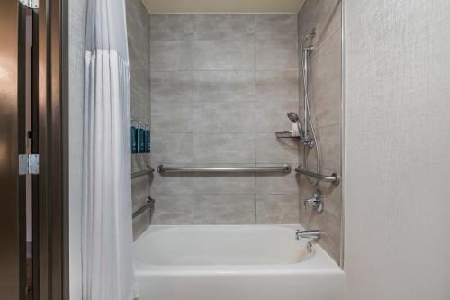 a bathroom with a white tub and a shower at The Newberry Hotel Bend, Tapestry Collection by Hilton in Bend