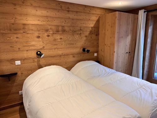 une chambre avec un lit dans un mur en bois dans l'établissement Appartement cozy 3 pièces avec terrasse et parking au centre, près des pistes - FR-1-464-235, à Pralognan-la-Vanoise
