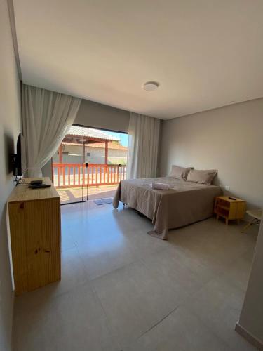 a bedroom with a bed and a large window at Encanto da Barra Pousada in Barra Grande