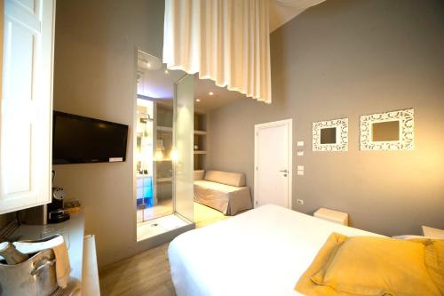 1 dormitorio con 1 cama y TV en una habitación en Le Stanze di Corteinfiore, en Trani
