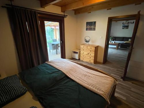Un dormitorio con una cama y una ventana grande. en Cozy 5 room house, en Drienovská Nová Ves