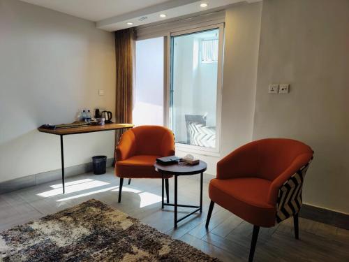 a living room with two chairs and a table and a window at Sky Lodge Hotel in Nathia Gali