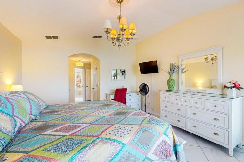 a bedroom with a bed and a dresser and a mirror at Palm Tree Paradise in Harlem Heights