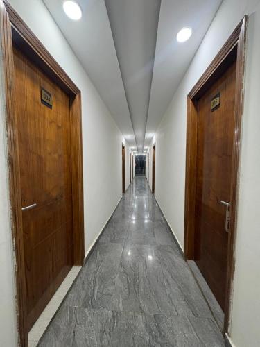 a corridor with two wooden doors and a hallway with a corridorngthngthngthngth at Radiant Blu Hotel in Noida
