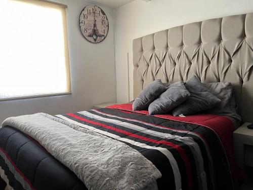 a bedroom with a large bed with pillows on it at Cálido y acogedor departamento cerca del centro in Tlaxcala de Xicohténcatl