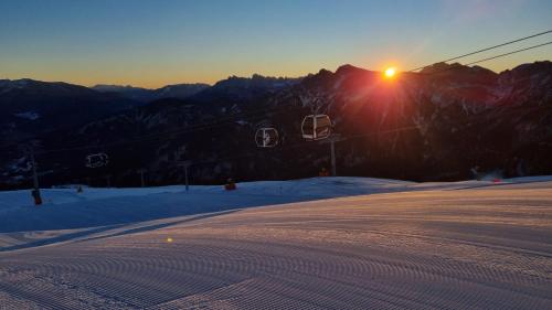 a sun setting on a ski slope with a ski lift at HausLiell in Falzes