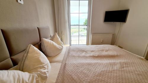 een slaapkamer met een bed, een tv en een raam bij Hafenidyll 46 in Ostseebad Karlshagen