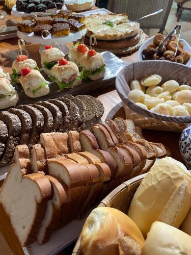 a table full of different types of bread and pastries at Recanto dos Vianas in Teresópolis