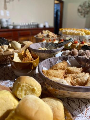 a table with plates of bread and bowls of food at Recanto dos Vianas in Teresópolis
