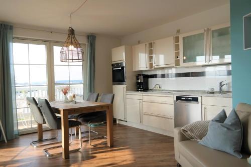 een keuken met een tafel en stoelen en een bank bij Hafenidyll 46 in Ostseebad Karlshagen
