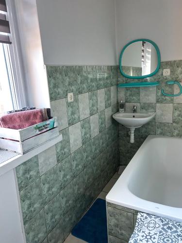 a bathroom with a tub and a sink and a mirror at DOLINA ROZTOKI-mieszkanie,pokoje lub domek z lokalem na poddaszu in Bircza
