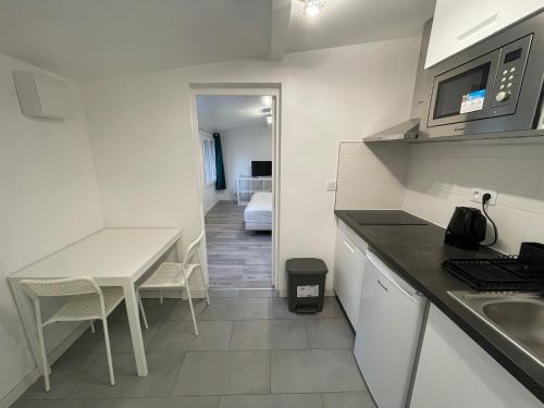 - une cuisine avec un évier et une table avec un comptoir dans l'établissement Studio jardin proche de transport, à Gagny