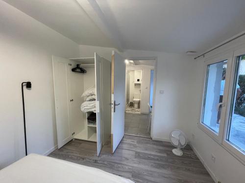 - une chambre avec une porte menant à une salle de bains dans l'établissement Studio jardin proche de transport, à Gagny