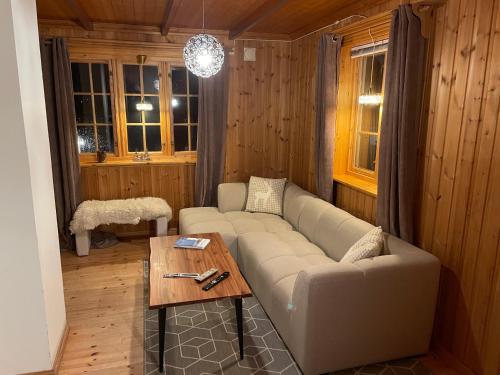 a living room with a couch and a table at Marvelous farmhouse with WiFi in Troms, Northern Norway in Nordøya