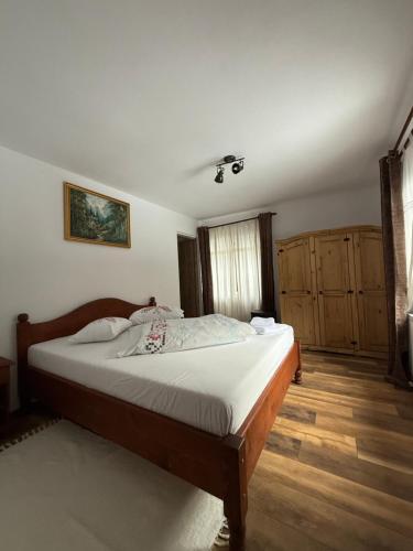 Un dormitorio con una cama grande en una habitación. en Casa Rosso, en Valea Măceşului