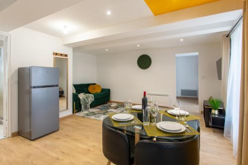un salon avec une table et un réfrigérateur dans l'établissement La promesse - T2 Hyper centre, à Abbeville