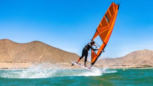 a man is wind surfing on the water at Hostal RustiKo Experiencias in Diaguita