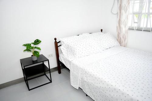 a bedroom with a bed and a plant on a night stand at Casa Bugambilia Door 2 in Balamban