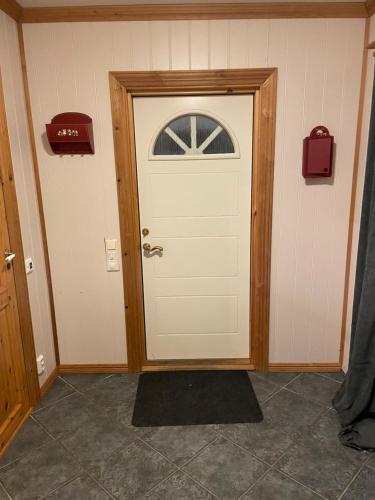a white door with a window on a wall at Marvelous farmhouse with WiFi in Troms, Northern Norway in Nordøya