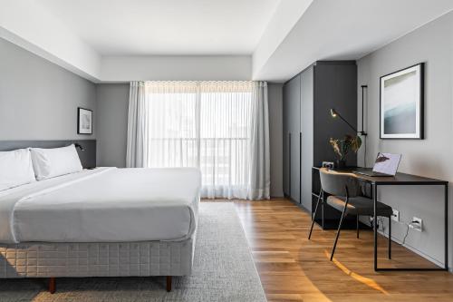 a bedroom with a bed and a desk with a computer at Studios Rio Branco by Viva - Prédio moderno, aptos com cama king-size no centro de Floripa in Florianópolis