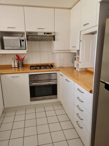 a kitchen with white cabinets and a stove top oven at San Alfonso del Mar Departamentos in Algarrobo
