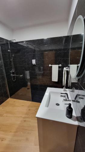 a bathroom with a sink and a mirror at Pôr do Sol I in Porto Moniz