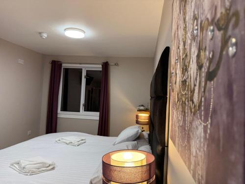 a small bedroom with a bed with two lamps on it at County Hotel in Helensburgh