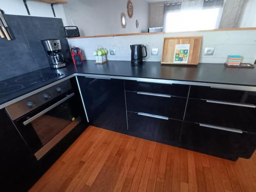 Il comprend une cuisine avec un comptoir noir et du parquet. dans l'établissement linge fourni 3 etoiles Proche mer et centre ville, à Saint-Gilles-Croix-de-Vie